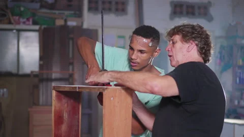Master Carpenter Teaching Apprentice Furniture Crafting in Workshop, divers.. Video stock 246766101
