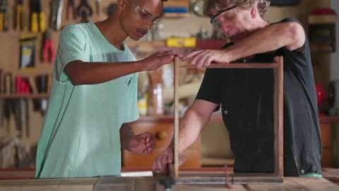 Master Carpenter Working with Apprentice at Carpentry Workshop, Senior Boss.. 스톡 사진