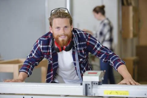 Master carpenter works on a machine in workshop Stock Photos
