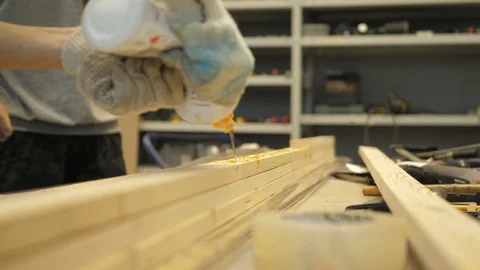 The master in the carpentry workshop glues the boards with special glue befor 動画素材 116312899