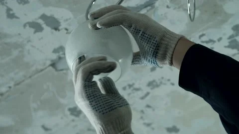 Master is changing the electric bulb in the chandelier. Stock Footage 169461753