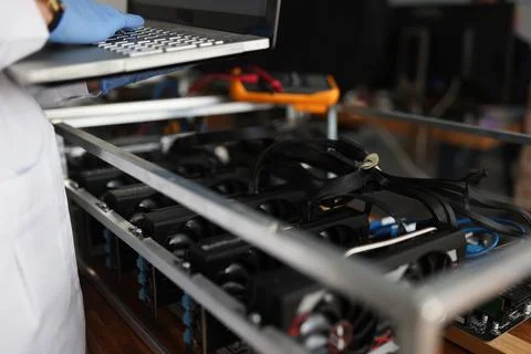 Master checking cryptocurrency mining rig using graphic cards closeup Stock Photos