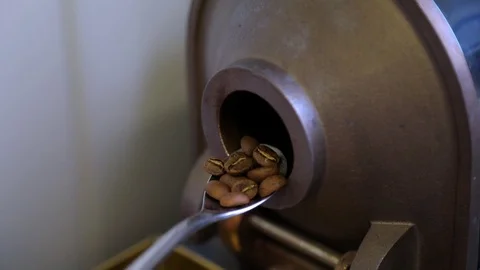 Master checks the degree of roasting coffee beans. Slow-motion. Stock-Footage 72707870
