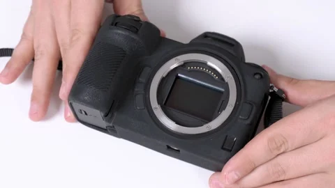 The master checks the matrix of mirrorless photo camera after prophylaxis and Stock Footage 132875971