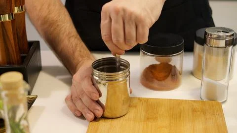 Master chef skillfully blends spices in containers, creating flavorful cuisine Foto stock