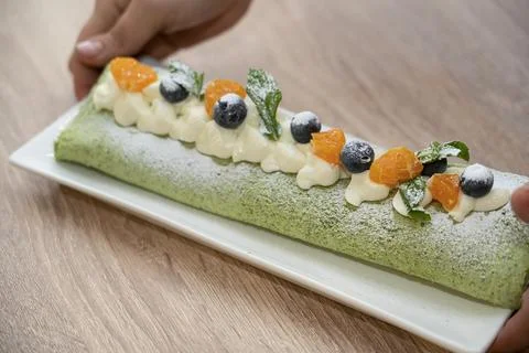 Master class on cooking desserts. Ready pistachio roll close-up. Stock Photos