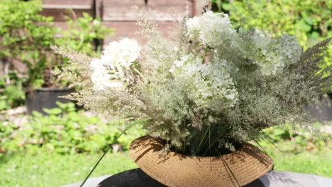 Master class of creating a floral arrangement in a straw hat with garden flowers 動画素材 278818182