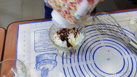 A master class on making ice cream. A child decorates with ice cream. Video stock 298665428