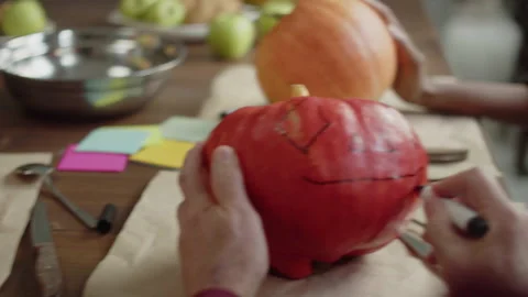 Master class on making pumpkin lamps. A man draws a grin on a pumpkin Stock Footage 163253818