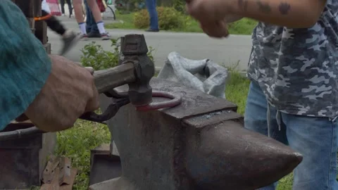 Master class, mastery. A blacksmith teaches a boy to forge a horseshoe. Stock-Footage 249457360