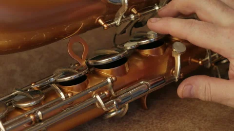 Master Cleans And Repairs The Saxophone Stock Footage 147975602