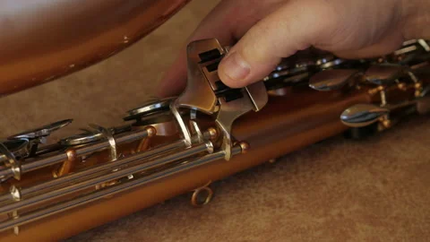 Master Cleans And Repairs The Saxophone Stock Footage 147975628