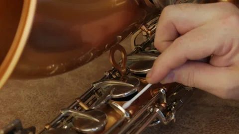 Master Cleans And Repairs The Saxophone Stock Footage 147975637