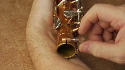 Master Cleans And Repairs The Saxophone Stock Footage 147975749