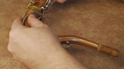 Master Cleans And Repairs The Saxophone Stock Footage 147975770
