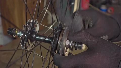 Master cleans the asterisk on the bicycle wheel with a brush. Workshop, bicycle Video stock 193483312