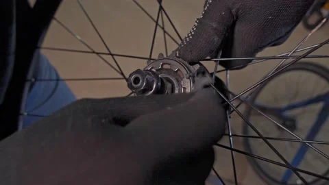 Master cleans the asterisk on the bicycle wheel with a brush. Workshop, bicycle Video stock 193484463
