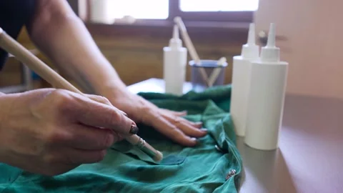 The master cleans the stain on the clothes with a special brush and a tool. The Stock Footage 161084050