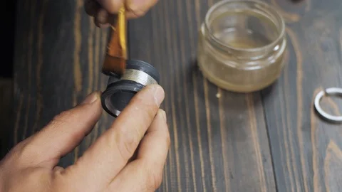 The master cleans the threaded part with a brush. repair of an old manual lens Stock Footage 119731290