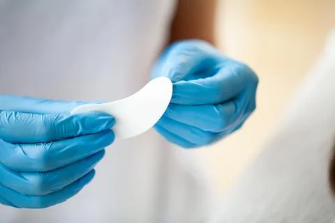 Master close up holding a patch for eyelash extensions Stock Photos
