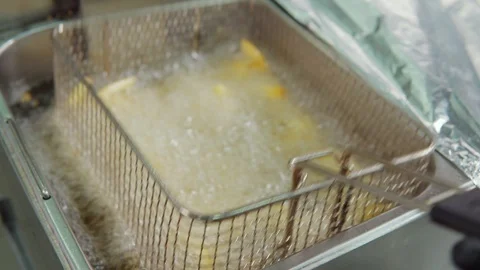 Master cook is deep-frying potatoes in kitchen of restaurant fast food Stock Footage 102978891