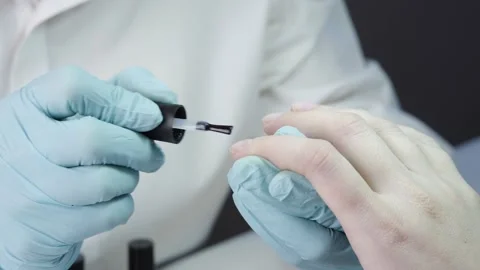 Master is covering the customer's nails with clear nail polish Stock Footage 194463896