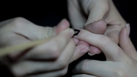 The master covers the client's nails with black varnish. Stock Footage 129522005