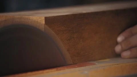Master craftsman cleaning and squaring mahogany edges with a table saw Stock Footage 251370506