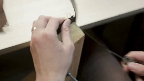 The master creates a black leather wallet with his own hands with a needle, t 스톡 동영상 81931746