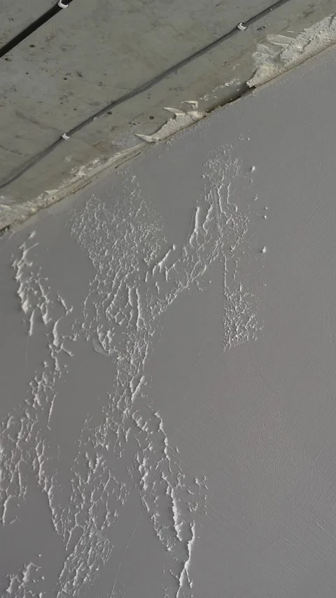 Master  creates a pattern on decorative plaster with a spatula and trowel Stock Footage 317409537