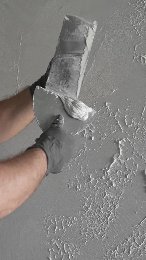 Master  creates a pattern on decorative plaster with a spatula and trowel Video stock 317409550