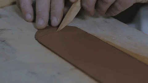 Master cuts the edge from a strip of clay with a wooden knife. teapot Yixing Stock Footage 119065837