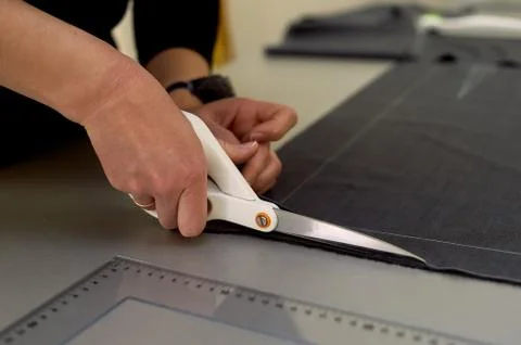 Master cuts fabric. Nesting. Suiting fabric marked with white chalk.Cutting and Stock Photos