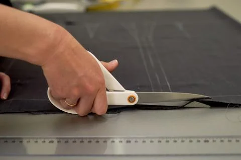 Master cuts fabric. Nesting. Suiting fabric marked with white chalk.Cutting and Stock Photos