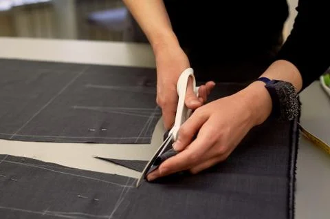 Master cuts fabric. Nesting. Suiting fabric marked with white chalk.Cutting and Stock Photos