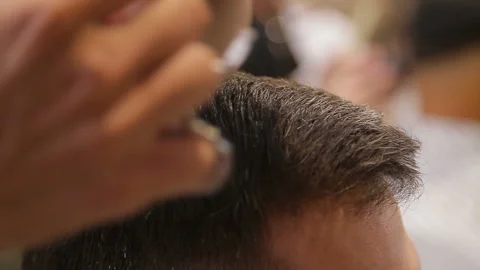Master cuts hair and beard of men in the barbershop, hairdresser makes hairstyle Video stock 93711972