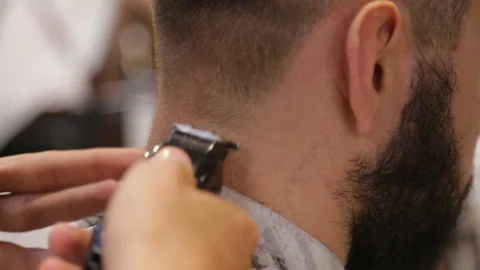 Master cuts hair and beard of men in the barbershop, hairdresser makes hairstyle Video stock 93712241