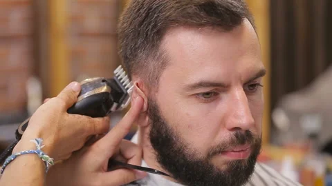 Master cuts hair and beard of men in the barbershop, hairdresser makes hairstyle Stock-Footage 93712355