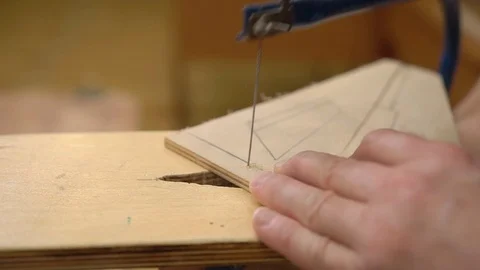 Master cuts outdated airplane model wing from brown plywood Stock Footage 126895733