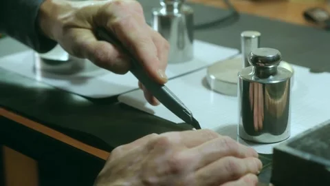 Master cuts pattern of leather with weights and paper shape Stock Footage 296748193