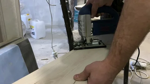 The master cuts off a section of the laminate with an electric jigsaw. Stock Footage 249312003