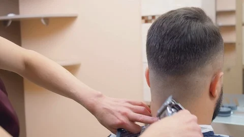 Master cutting hair with black comb and clipper, close shot. Males close-croped Stock Footage 120106951