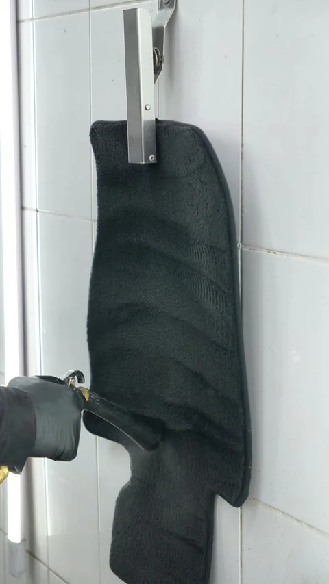 Master detailer does dry cleaning and drying of carpeted car mats. car interior Stock Footage 328580956