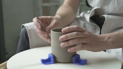 Master different tools grind a clay mug on a potter's wheel. Stock Footage 87326154