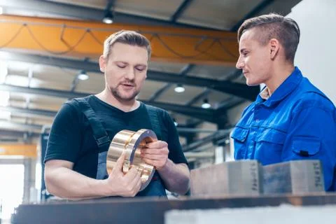 Master discussing a workpiece with his apprentice or trainee 스톡 사진