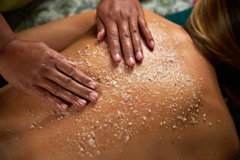 The master does a back massage with special oils and sea salt, spa treatments Stock Photos