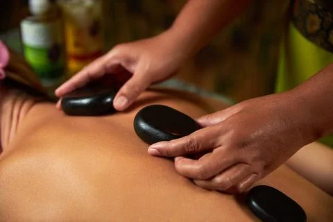The master does back massage with special stones, spa treatments, magnets Stock Photos