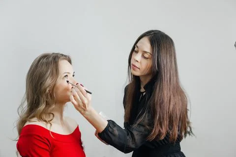 Master does a beautiful blonde makeup in a beauty salon Stock Photos