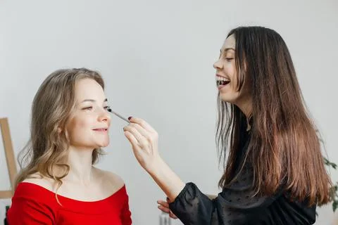 Master does a beautiful blonde makeup in a beauty salon Stock Photos