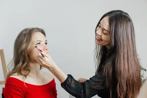 Master does a beautiful blonde makeup in a beauty salon Stock Photos